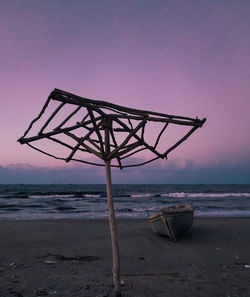 Lifeguard hut on beach against sky during sunset