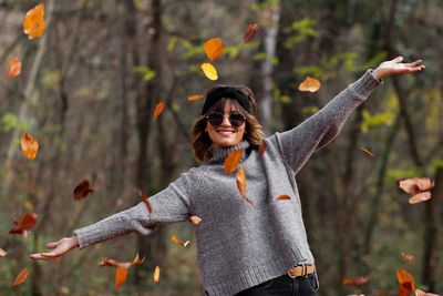 Young woman wearing warm clothing at public park during autumn