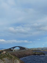 Arch bridge over sea against sky