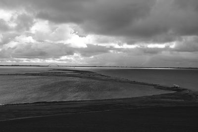 Scenic view of beach against cloudy sky