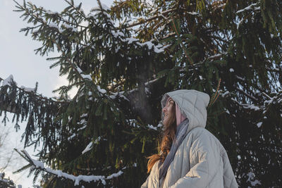 Woman with freckles in winter clothes outdoors enjoying winter and smiling