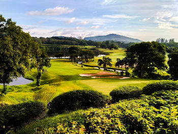 Scenic view of golf course against sky