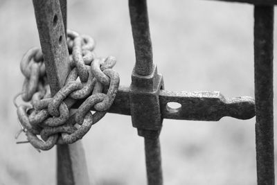 Close-up of old chain on metal railing