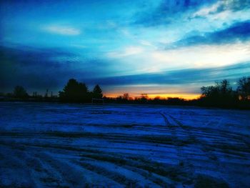 Scenic view of snow covered landscape against blue sky