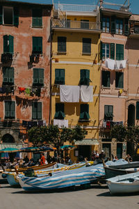 Boats moored in canal amidst buildings in city