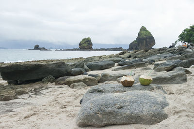 Rocks on beach against sky