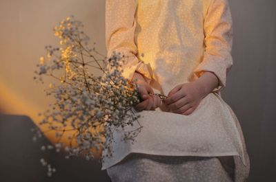 Midsection of woman holding autumn leaf