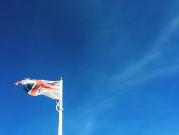 Low angle view of flags against blue sky