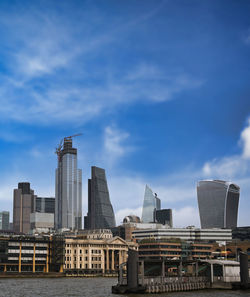 Buildings in city against cloudy sky