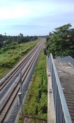 Railroad tracks by trees against sky