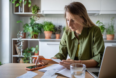 Young woman using laptop at table