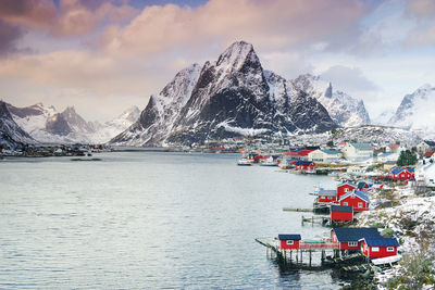 Scenic view of sea by snowcapped mountains against sky