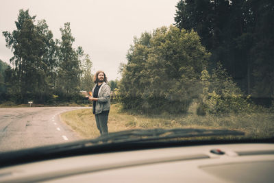 Full length of man seen through car windshield