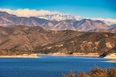 Scenic view of sea and mountains against sky