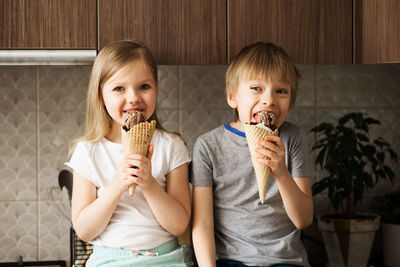 Siblings eating ice cream at home