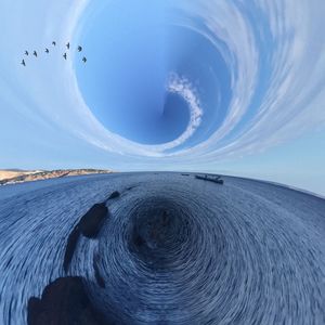 Fish-eye view of sea against blue sky