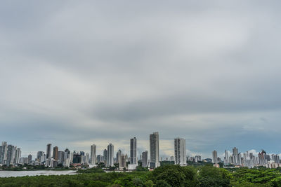 Buildings in city against cloudy sky