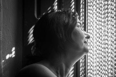 Close-up of woman looking through window