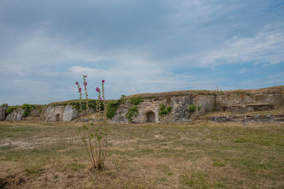 Built structure on field against sky