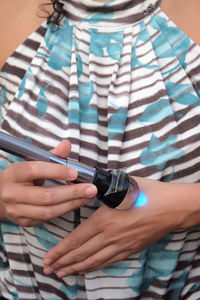 Midsection of woman holding umbrella