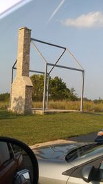 Built structure on field seen through car windshield