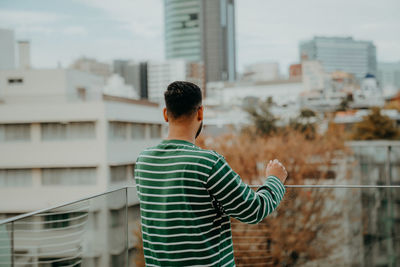 Rear view of man standing against building