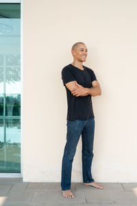 Portrait of young man standing against wall