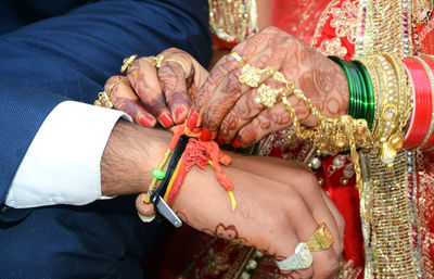 Midsection of couple holding hands