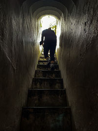 Rear view of man standing on staircase
