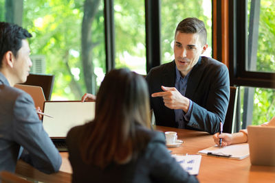 People working by table in office