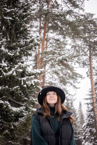 Portrait of young woman standing in forest