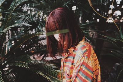 Rear view of woman with leaves on tree