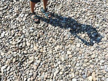 Low section of person standing on pebbles
