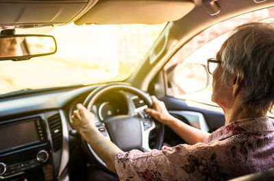 Rear view of woman sitting in car