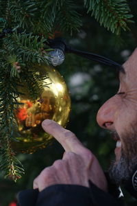 Close-up of man touching christmas decoration