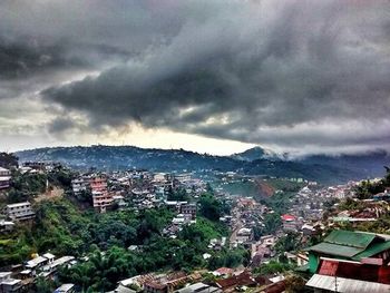 Buildings in city against cloudy sky