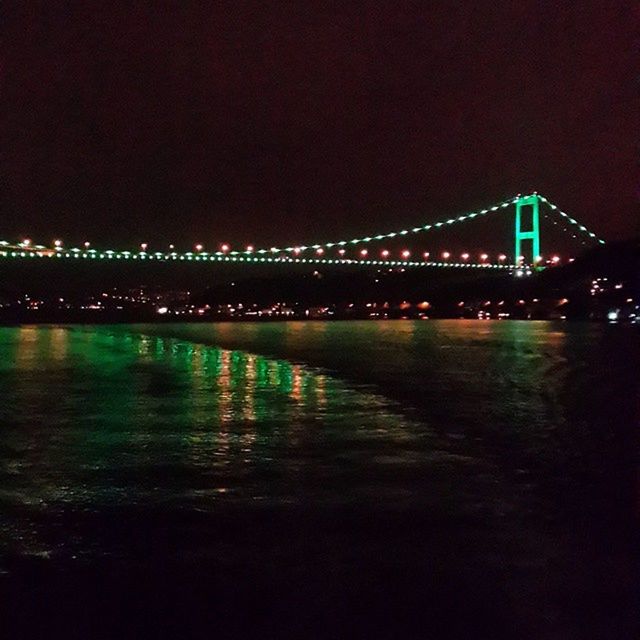 illuminated, night, connection, bridge - man made structure, water, architecture, built structure, river, bridge, waterfront, engineering, copy space, city, suspension bridge, reflection, clear sky, travel destinations, sea, no people, outdoors