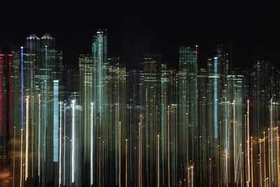 Illuminated cityscape against sky at night