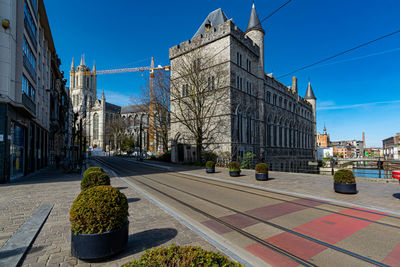 Street amidst historic buildings against blue sky