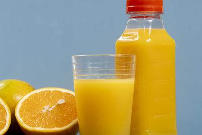Natural orange juice in the glass with bottle on the side