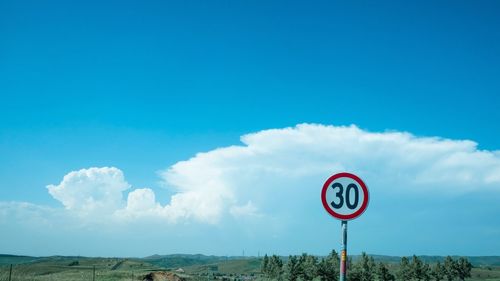 Road sign against blue sky