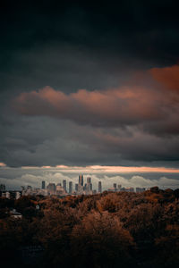 Storm clouds over city at sunset