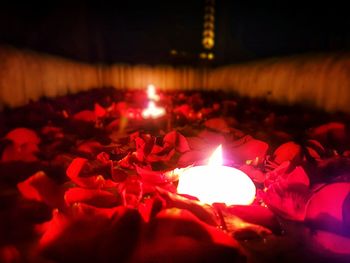 Close-up of lit candles in dark room