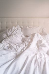 Close-up of white pillows and sheet on bed