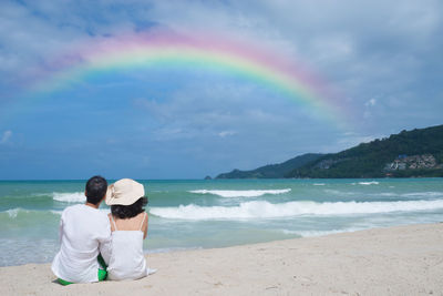 Rear view of friends standing on beach