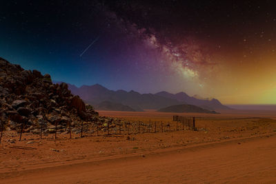 Scenic view of arid landscape against sky at night