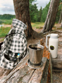 Rear view of woman holding coffee on field