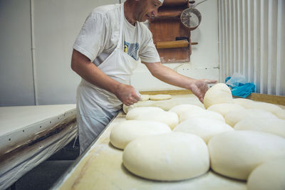 Man arranging rounds of dough at a bakery in belgrade, serbia