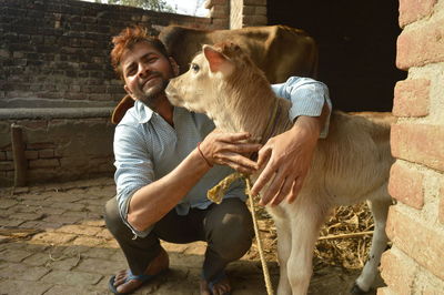 Full length of man crouching while embracing 