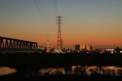 Cranes against sky at sunset